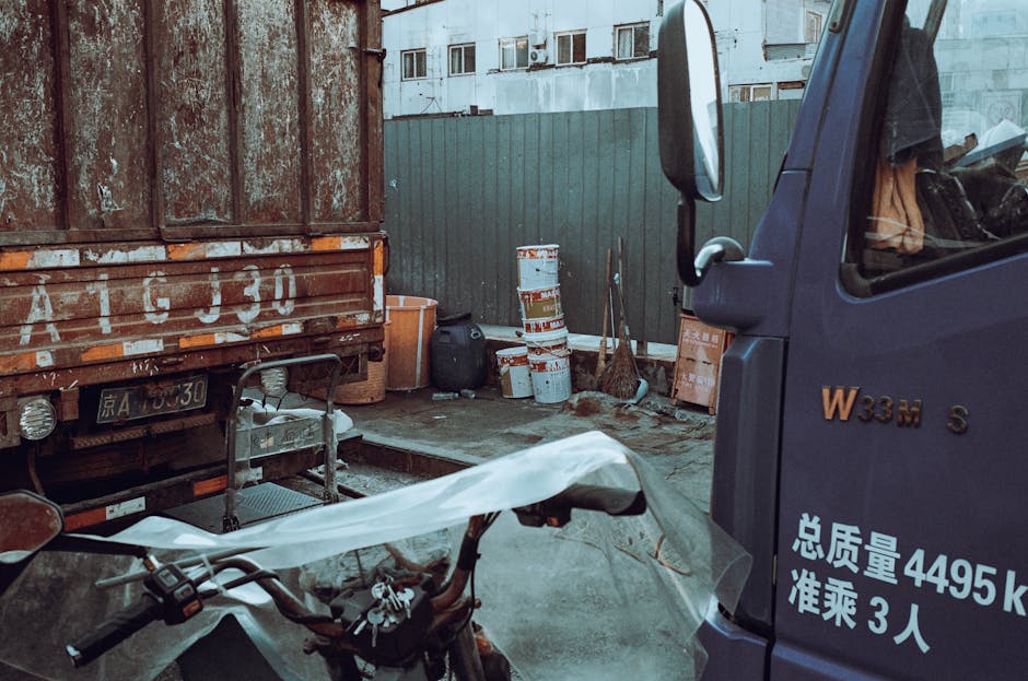 An industrial yard with parked trucks, showing urban equipment and storage containers.